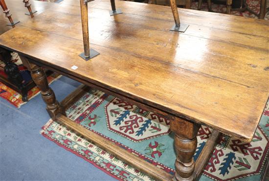 A 17th century style oak centre table, with planked top on turned legs and peripheral stretcher, W.168cm